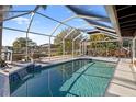 Inviting screened-in pool area with a waterfall feature and ample space for lounging and enjoying the outdoors at 4806 Bay Crest Dr, Tampa, FL 33615