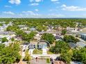 Aerial view showcases the home's location amidst lush greenery and a nearby coastal skyline, emphasizing its prime setting at 6318 S Harold Ave, Tampa, FL 33616