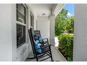 Inviting front porch with rocking chairs and a view of well-maintained landscaping at 6318 S Harold Ave, Tampa, FL 33616
