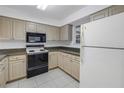 Compact kitchen featuring a white refrigerator, tile backsplash, and dark appliances at 6826 Stones Throw N Cir # 11104, St Petersburg, FL 33710