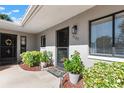 Close-up of the front entrance with a welcome mat and potted plants near the front door with glass at 7737 Eureka Dr # 203, Hudson, FL 34667