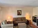 Cozy living room with a tan sofa and armchair, a floral rug, lamps and decorative art at 8100 Dr Martin Luther King Jr N St # 302, St Petersburg, FL 33702