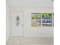 Inviting entryway featuring a decorative front door, tiled floor, and natural light from a large window at 8725 N Boulevard, Tampa, FL 33604