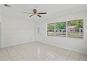 Spacious living room with neutral walls, tiled flooring, and a large window offering ample natural light at 8725 N Boulevard, Tampa, FL 33604