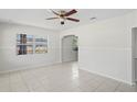 Bright living room showcasing tiled floors, a ceiling fan, and a decorative archway leading to other spaces at 8725 N Boulevard, Tampa, FL 33604