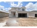Two-story home featuring a light gray exterior, attached two-car garage, and covered entryway at 10644 Crescent Creek Xing, Parrish, FL 34219