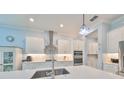 Bright kitchen with stainless appliances, white cabinets, and a large center island with a sink at 17152 Scuba Crest St, Wimauma, FL 33598