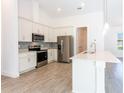 Modern kitchen features stainless steel appliances, a center island, and sleek countertops at 17406 Isaac Ln, Punta Gorda, FL 33955
