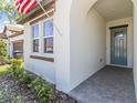 Welcoming front porch with a blue-green door and brick-paved walkway at 17418 Holly Well Ave, Wimauma, FL 33598