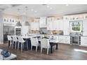 Modern kitchen features a large island, stainless steel appliances, and pendant lighting at 17716 Roost Pl, Lakewood Ranch, FL 34211