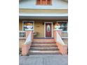 Inviting front porch featuring classic brick steps, and seasonal floral arrangements at 2222 Harper St, Tampa, FL 33605