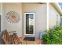 Inviting front porch features a decorative bench, sun-shaped wall art, and colorful plantings at 31820 Blythewood Way, Wesley Chapel, FL 33543