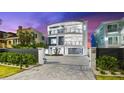 Modern, multi-story home with a sleek design, balcony views, and a paved driveway at 32 Gulf Blvd, Indian Rocks Beach, FL 33785