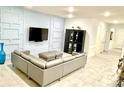 Comfortable living room featuring stylish wall accents, tile flooring and an L shaped couch at 33298 Major Oak Dr, Wesley Chapel, FL 33545