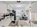 Cozy kitchen with white cabinetry, practical appliances, and a functional layout for everyday cooking at 4235 Richmere Dr # 4235, New Port Richey, FL 34652