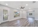 Bright living room featuring new gray wood floors, neutral paint, and a ceiling fan at 4509 26Th S Ave, Tampa, FL 33619