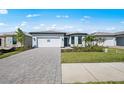 Beautiful single-story home featuring a brick driveway and lush green landscaping at 4597 Blue Star Ct, North Port, FL 34289