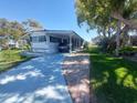 Charming home featuring a painted driveway and shaded carport at 46 Washington Ct # 28, Palm Harbor, FL 34684