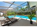 A refreshing screened-in pool area with lounge chairs and lush greenery, perfect for relaxation and leisure at 5232 Kirkwood Ave, Spring Hill, FL 34608