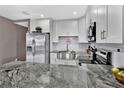 Modern kitchen with stainless steel appliances, white cabinets and a granite countertop at 6208 Florida W Cir, Apollo Beach, FL 33572