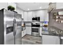 Modern kitchen with stainless steel appliances, white cabinets and a large island at 6208 Florida W Cir, Apollo Beach, FL 33572