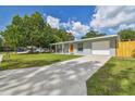 Charming single-story home with a well-manicured lawn, a covered front porch, and an attached garage at 1260 S Hillcrest Ave, Clearwater, FL 33756