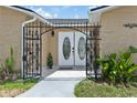 Charming entryway featuring decorative iron gate and well maintained plants at 13701 Garris Dr, Hudson, FL 34667
