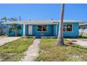 Blue single Gathering home with walkway and mature landscaping in the front yard at 14040 Miramar Ave, Madeira Beach, FL 33708