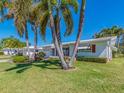 Attractive home displaying healthy green lawn and swaying palm trees under a clear blue sky at 14173 90Th Ave, Seminole, FL 33776