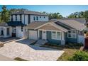 A craftsman-style house featuring a brick driveway, attached garage, front garden, and two-story adjacent building at 1510 49Th N St, St Petersburg, FL 33710