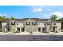 Townhome with a green accent and a private garage, complemented by black shutters and fresh landscaping at 17519 Spanish Oak Loop, Land O Lakes, FL 34638