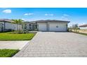 Charming single-Gathering home features a paved driveway, a two-car garage, and landscaped front yard at 1895 Ridgemore St, North Port, FL 34289