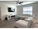 Relaxing living room showcasing a modern fireplace, TV, and comfortable white sectional couch at 31888 Treasure Dock Isle, Wesley Chapel, FL 33545