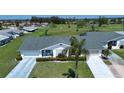 An aerial view of a well maintained single-story home, with a lush green lawn and a long driveway at 322 Club Manor Dr, Sun City Center, FL 33573