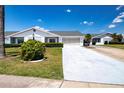 Charming single-story home featuring well-maintained landscaping and an attached garage at 322 Club Manor Dr, Sun City Center, FL 33573