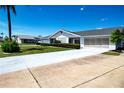 Charming single-story home featuring well-maintained landscaping and an attached garage at 322 Club Manor Dr, Sun City Center, FL 33573