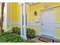 Charming yellow home featuring a white front door, mailbox, and manicured landscaping at 4766 Snook Se Dr, St Petersburg, FL 33705