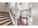 Inviting foyer with elegant double doors, wood flooring, and a staircase with decorative iron railings at 5324 Moon Shell Dr, Apollo Beach, FL 33572
