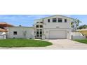 Beautiful two-story home boasts a manicured lawn and a welcoming front entrance with modern design elements at 540 59Th Ave, St Pete Beach, FL 33706