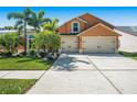 Charming two-story home with a three-car garage, lush landscaping, and a well-maintained driveway at 7116 Colonial Lake Dr, Riverview, FL 33578