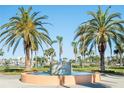 Beautiful fountain surrounded by lush greenery and palm trees on a sunny day at Coral Pointe at 8020 Sailboat Key S Blvd # 404, St Pete Beach, FL 33707