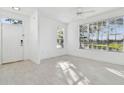 Sunlit living room showcasing pristine white walls and contemporary tile flooring at 9008 Lake Chase Island Way, Tampa, FL 33626