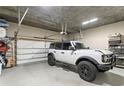 Spacious garage with epoxy flooring, storage shelving, and a new white 2023 Ford Bronco parked inside at 146 4Th Ne Ave # 600, St Petersburg, FL 33701