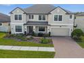 Two-story home with a well-maintained lawn, appealing landscaping, and an attached garage at 19432 Whispering Brook Dr, Tampa, FL 33647