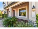 Covered front porch featuring stone accents, decorative lights, and a stylish front door at 19432 Whispering Brook Dr, Tampa, FL 33647