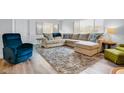 Bright living room features an L-shaped sofa, plush rug, and wood-look flooring at 2348 Shelley St # 8, Clearwater, FL 33765