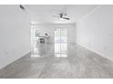 Bright living area features new tile floors, modern ceiling fan, and sliding doors to the outside at 2523 Northfield Ln, Clearwater, FL 33761