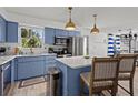Charming blue and white kitchen with stainless steel appliances, island, and eat-in bar at 3457 Cyclone Dr, Weeki Wachee, FL 34607