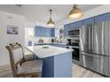 Modern kitchen features blue cabinets, stainless appliances, and a marble-topped island at 3457 Cyclone Dr, Weeki Wachee, FL 34607