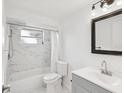 Modern bathroom featuring a shower with bathtub, with marble tile and sleek fixtures at 3646 Springfield Dr, Holiday, FL 34691